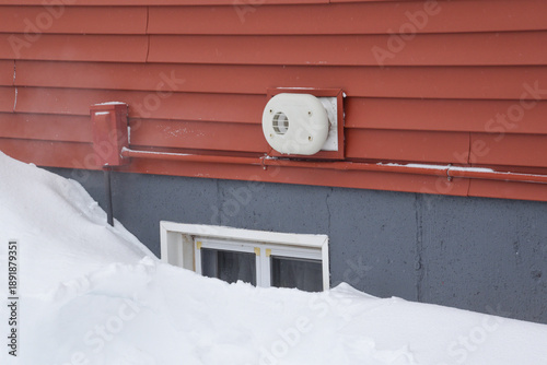 Furnace or boiler exhaust vent on outside of house with steam coming out. Keeping house exhaust clear of snow to prevent carbon monoxide poisoning. Clear away snow from home vents for safety
