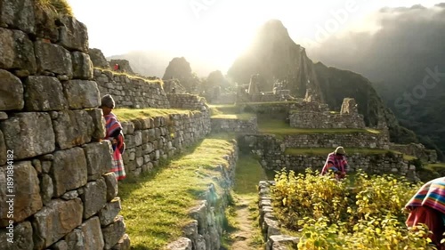 People working in machu picchu terraces with ancient inca ruins and misty mountains in background, cinematic motion footage