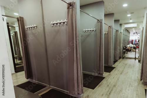 Fotografie Interior of a clothing store fitting room featuring multiple gray changing stall