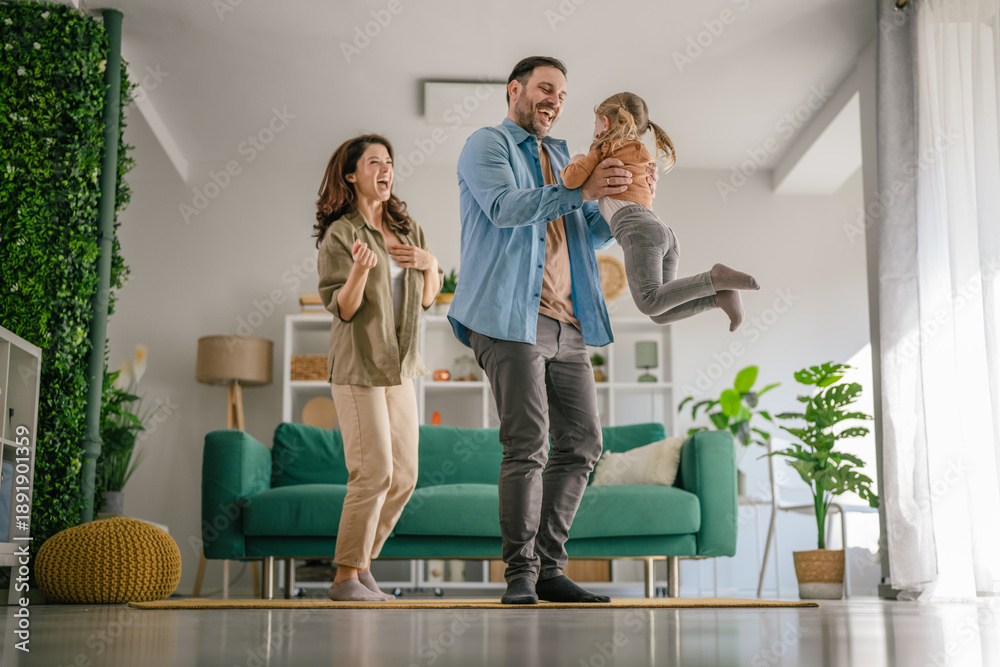 Fototapeta premium Happy family playing together in bright living room