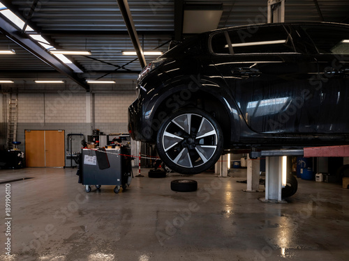 Fotografie Car workshop workbench area with various tools and supplies, tiled wall backgrou