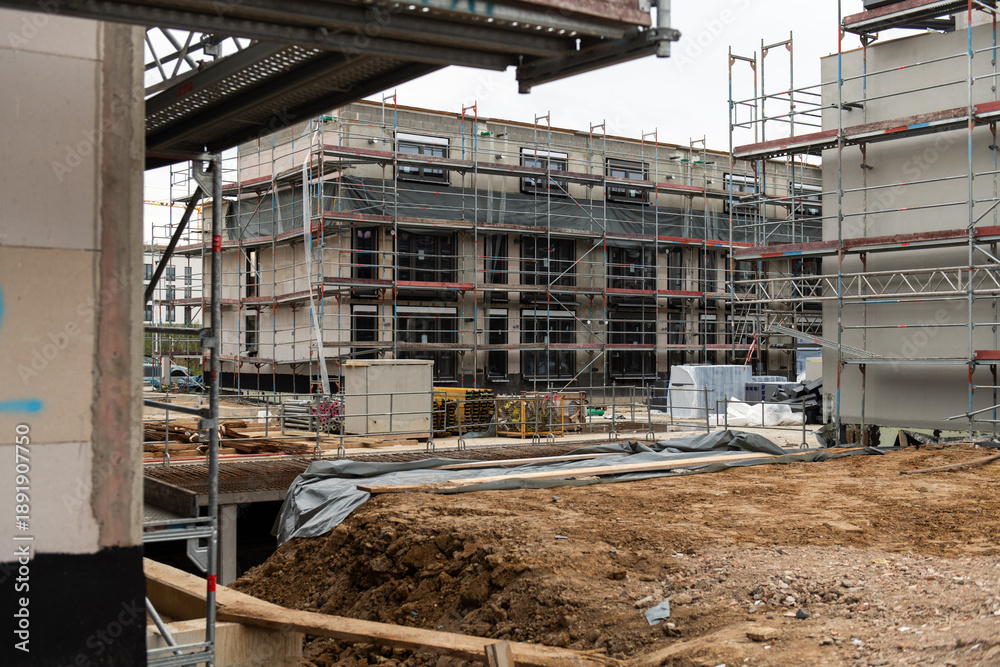 Fototapeta premium construction site showing an unfinished apartment building. House under construction. shell construction with building material, tools and scaffolding. future property real estate