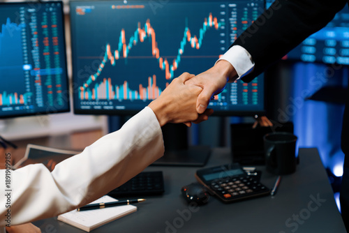Fotografi Cropped hand of business partner checking hand with dynamic stock market data analyzing profit value currency rate online website program application background pc screen at modern office