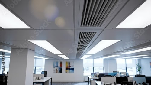 Bright modern office interior with fluorescent ceiling lights and air conditioning grilles