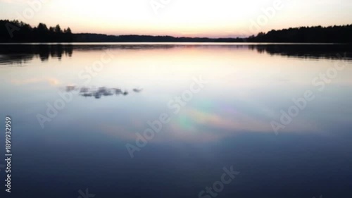 Iridescent Water Surface A close-up, tranquil shot of still lake water revealing vibrant, swirling thin-film interference patterns, like oil on water, with a gentle, hypnotic motion.