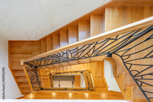 Obraz na plátně Elegant wooden staircase with custom wrought iron railing in a modern residentia