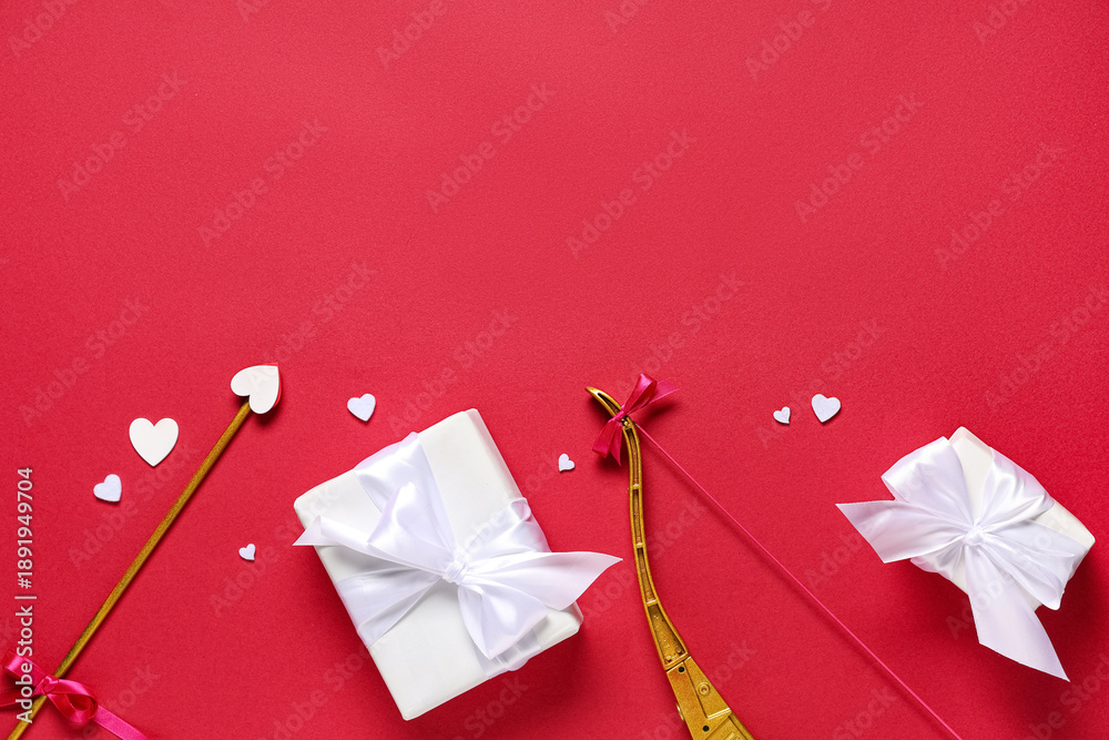 Fototapeta premium Composition with cupid's bow, gift boxes and paper hearts on red background. Valentine's Day celebration