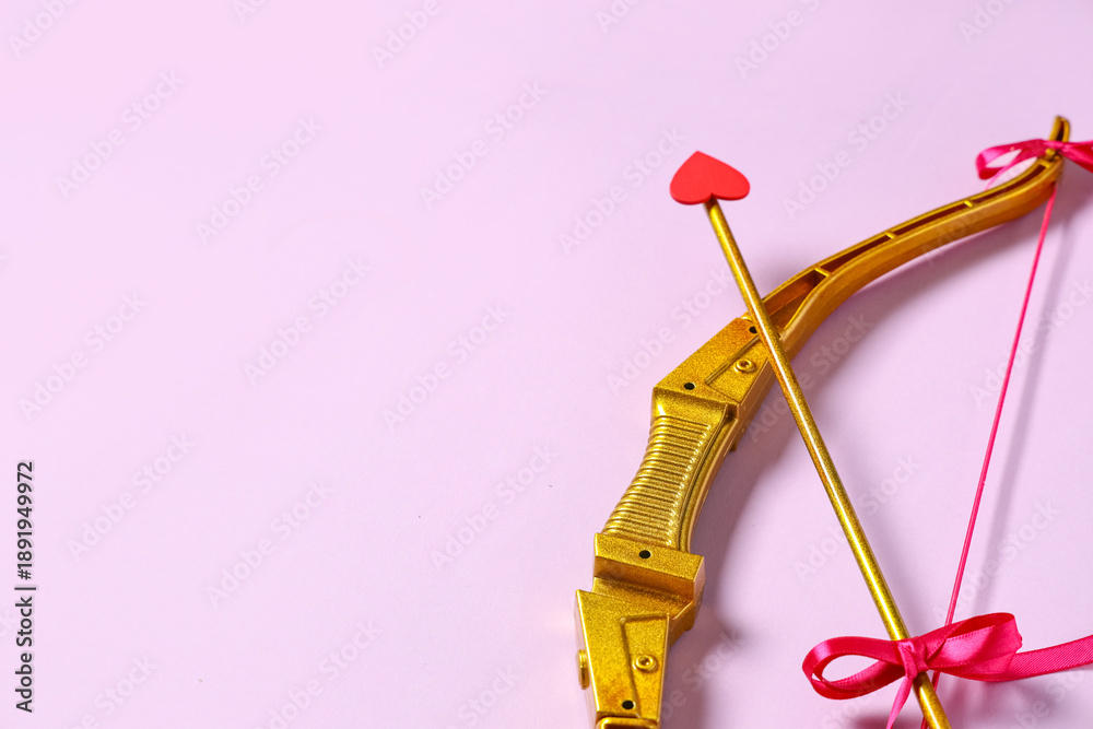 Fototapeta premium Golden cupid's bow with arrow on lilac background. Valentine's Day celebration