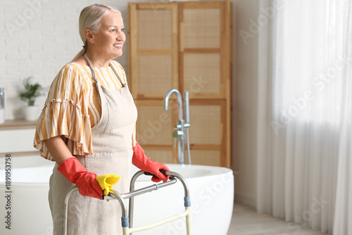 Mature woman with walker and rag in bathroom