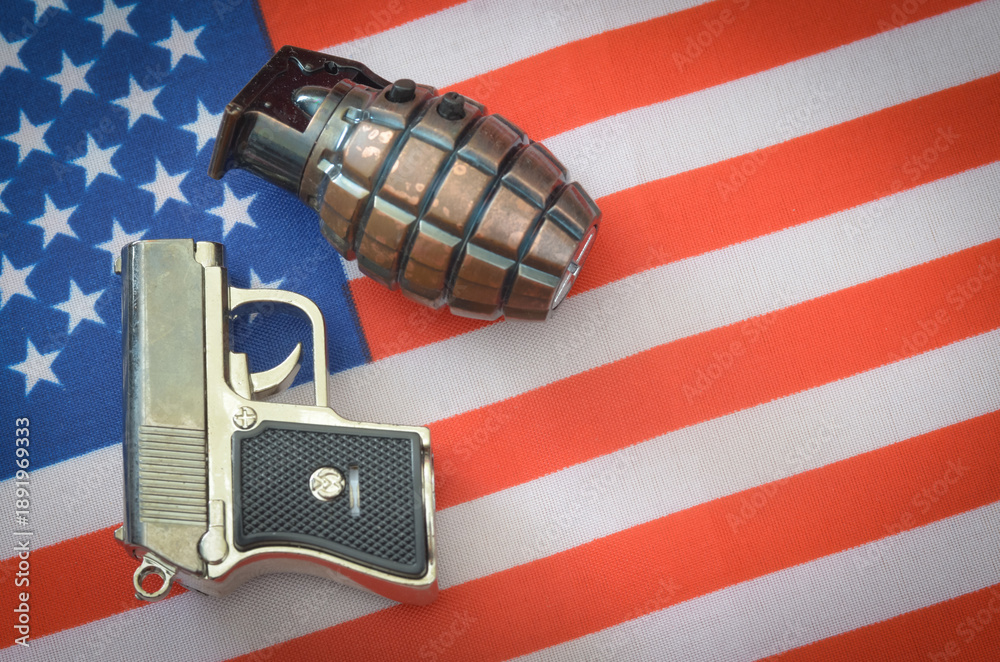 Obraz premium Grenade and Pistol Placed Over American Flag Evoking Themes of Defense and Controversy