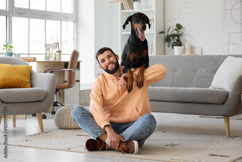 Young man with Dobermann do...