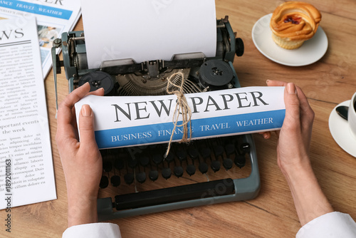 Female hand holding newspap...