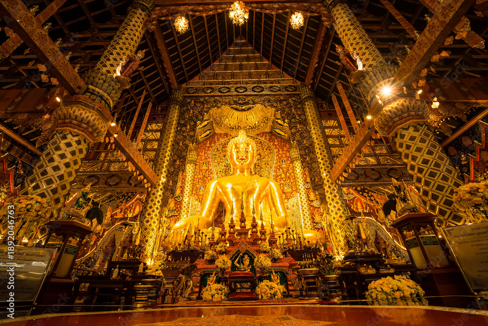 Obraz premium Chiang Mai, Thailand - January,08, 2026:Golden Shrine of Tranquility: The interior of a magnificent temple shimmers with ornate golden details, a large statue of buddha sits as the focal point