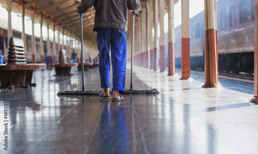Fototapeta premium Worker diligently cleaning train station platform floor