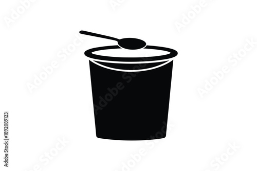 A yogurt glass with a spoon on it isolated over white background with copy space