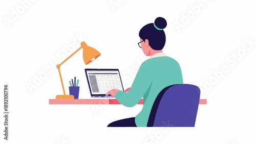 A woman with glasses and a bun sits at a desk, working diligently on her laptop under the warm glow of a desk lamp.