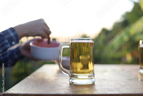 The party was held in the backyard in the evening as the sun was setting. The atmosphere was joyful and fun. Everyone helped prepare the food, including grilling meat, and alcoholic drinks were served