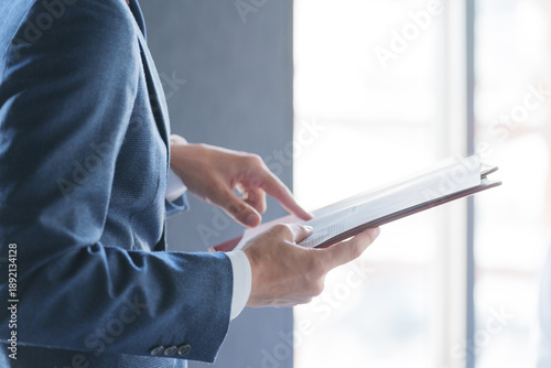Bild auf Leinwand 紙資料を指差しチェックする男性ビジネスマン