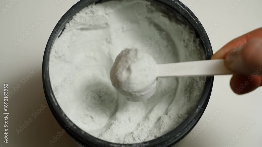 custom made wallpaper toronto digitalHand scooping a full scoop of creatine from a jar, close-up, top view