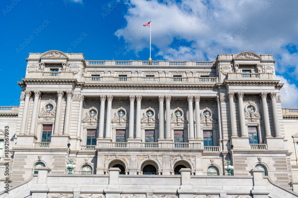 Obraz premium Congress building under blue sky. Washington DC landmark. American flag above the Congress library. USA Congress. Congress historic symbol of American democracy