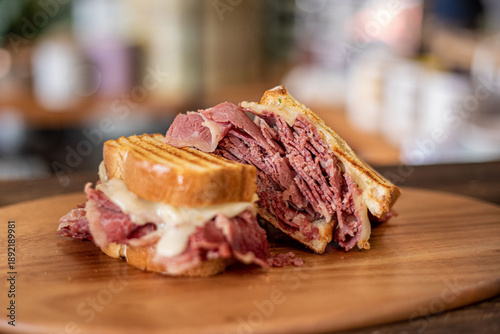 Bild auf Leinwand A corned beef sandwich on a wooden board in a modern restaurant