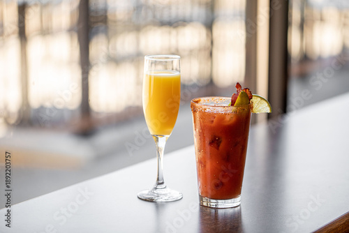 Obraz na płótnie A champagne mimosa with orange juice and a bloody mary with olives in a bright w