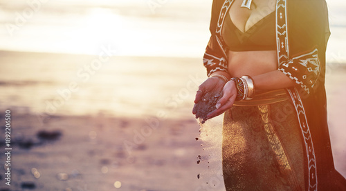 Photos Woman, hands and sand on beach for sunset, culture and boho fashion at sea