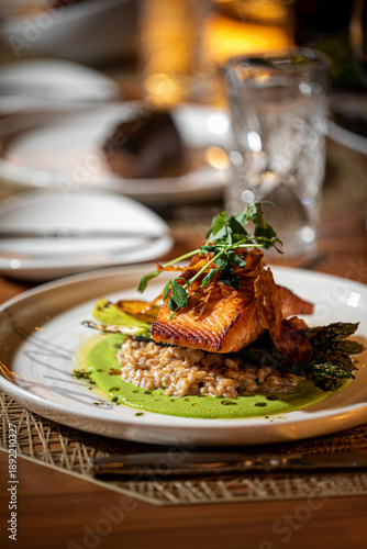 Salmon on a white plate served on a table at a high end restaurant 