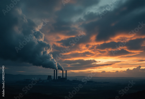 Принти на полотні Industrial Power Plant Emitting Smoke Against a Dramatic Sunset Sky