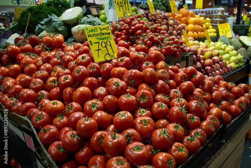 Fresh red tomatoes on display at grocery store market stall