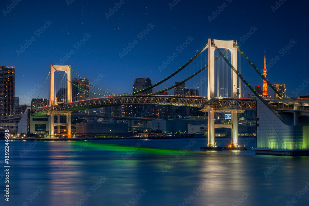 Fototapeta premium Tokyo Rainbow Bridge Illuminated at Night with City Skyline and Bay Reflections Panorama
