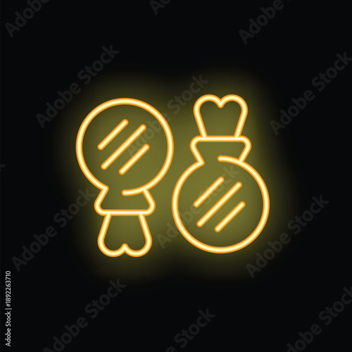 Yellow neon icon of traditional spanish musical instrument castanets glowing on black wall