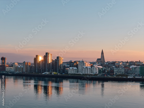 Reykjavik city skyline reflecting golden hour sun on water