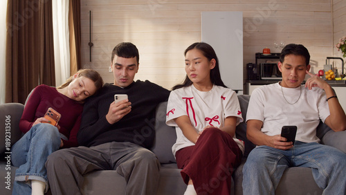 Foto Sad ignore friends sit couch at home living room using smartphone