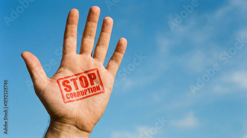 Hand with Stop Corruption Stamp Against Sky  
