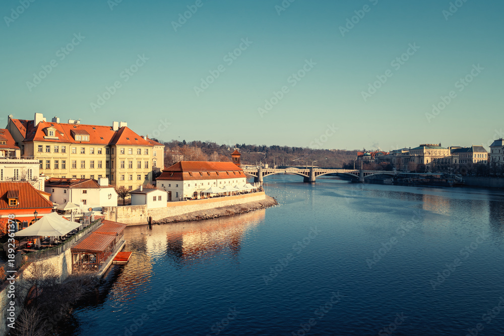 Obraz premium Cityscape of Prague with Vltava River, beautiful buildings of Mala Strana and Manesuv bridge in morning light, Czech Republic