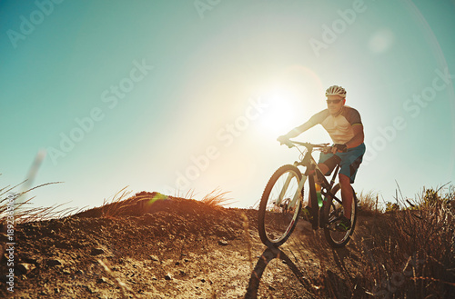 Wallpaper Mural Countryside, mountain bike and man with training, low angle and travel with journey, practice and endurance. Cyclist, healthy person or bicycle with hobby, wellness or helmet for safety and challenge Torontodigital.ca