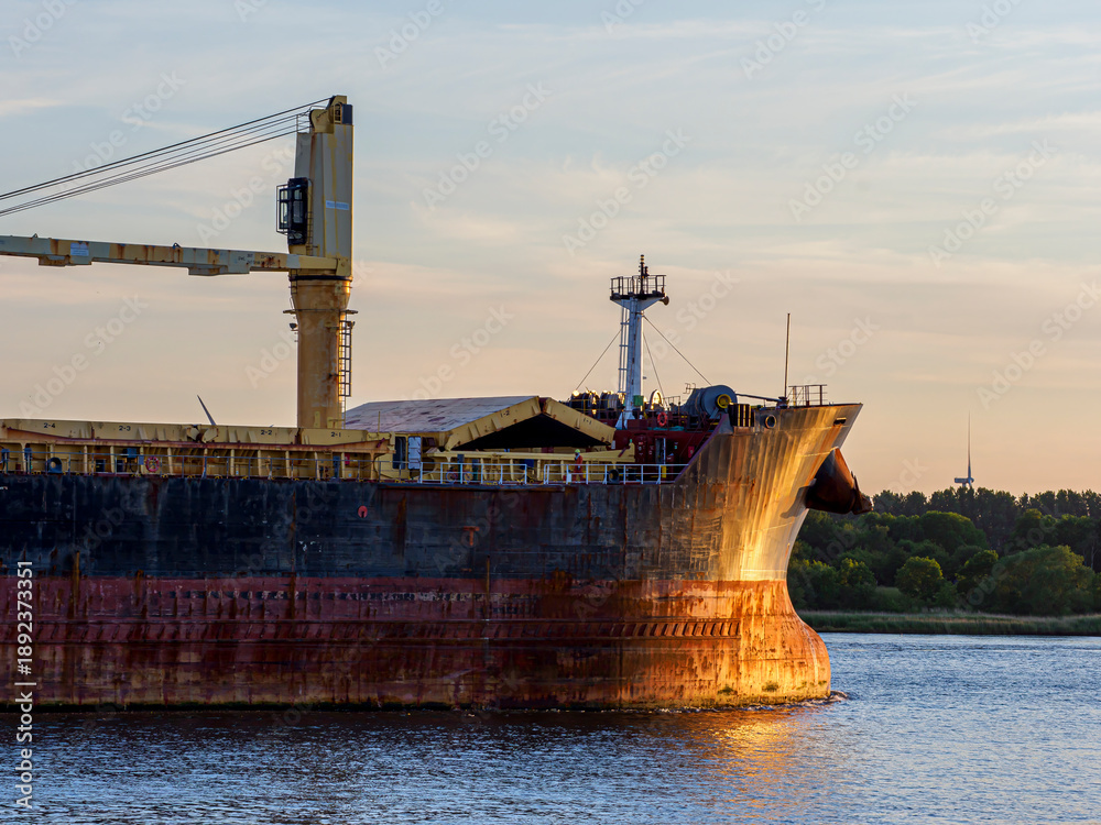 Fototapeta premium Bulk carrier ship sailing on the Noordzee Canal at sunset