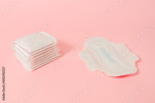 Sanitary napkins packed on pink background. Menstruation cycle, feminine hygiene and protection. Flat layout