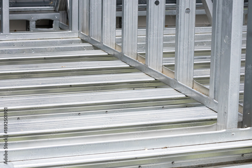 Obraz premium Metal stud framing system with rust resistant coating in a drywall assembly. Metal house frame. Construction of a private frame house. Steel wall frames. Construction background, house construction.