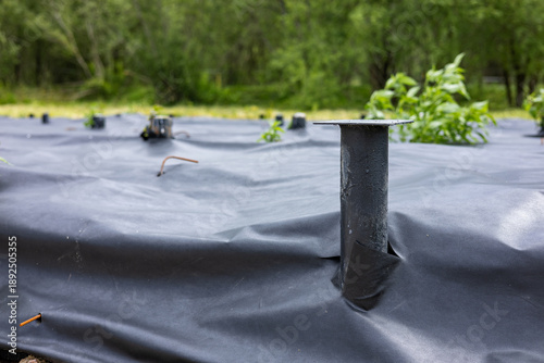 Bild auf Leinwand Construction of a pile foundation using metal screw piles and geotextiles