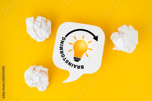 Fotografie brighten lightbulb inside circle with brainstorming text on real white speech bu