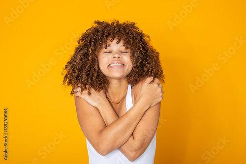 Tableau sur toile young woman isolated, smiling and hugging herself