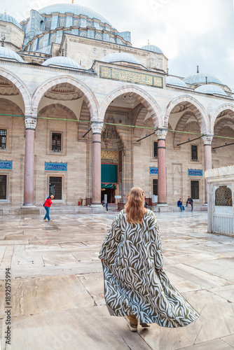 Woman in a traditional oriental robe in the courtyard of the Suleymaniye Mosque.