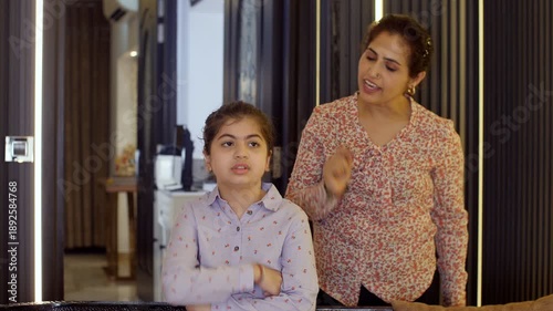 An angry and an annoyed Indian woman screaming / shouting at her little girl - parenting issues  confrontation. A frustrated Indian mother scolding her little daughter - family issues  a misunderst...