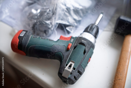 Wallpaper Mural Professional DIY hand tools set on a white surface including a cordless power drill, rubber mallet, utility knife, and metal drawer slides. Home renovation, furniture assembly, and repair concept. Torontodigital.ca