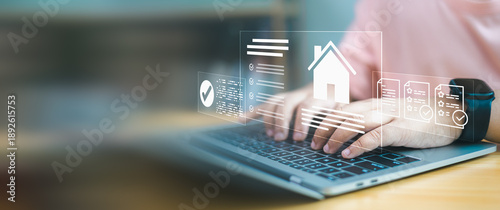 Fotografie Close up of hands typing on laptop with smart home interface and digital property documents