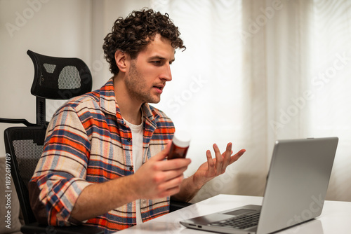 Foto Young man sitting in living room, communicating with healthcare professional via video call on laptop, discussing his medical condition and treatment options