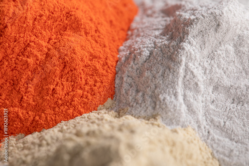 Tableau sur toile An angled, close-up photo shows three distinct mounds of high-quality nanostructured powder paint in bold orange, bright white, and pale beige