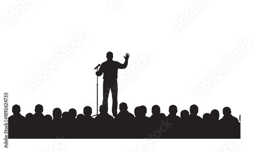Silhouette of a speaker addressing a large audience from a stage with a microphone.